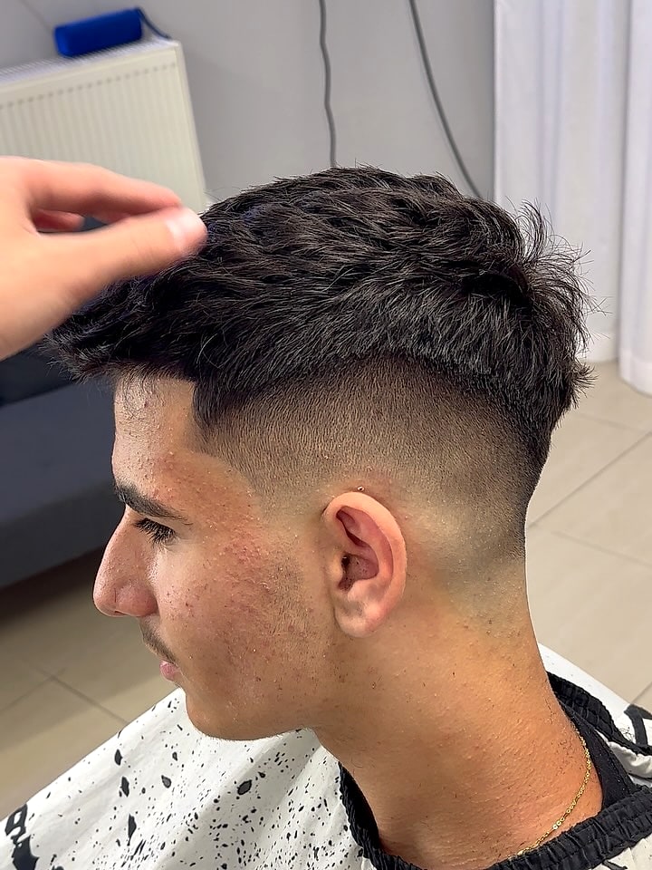 Ψηλό skin fade με κοφτή γραμμή στον κρόταφο και υφή στην κορυφή